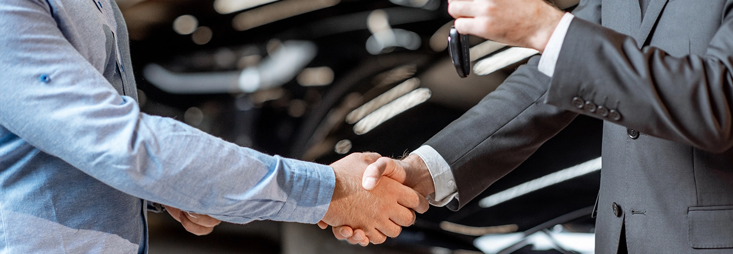 Driver in car shaking hands with another person